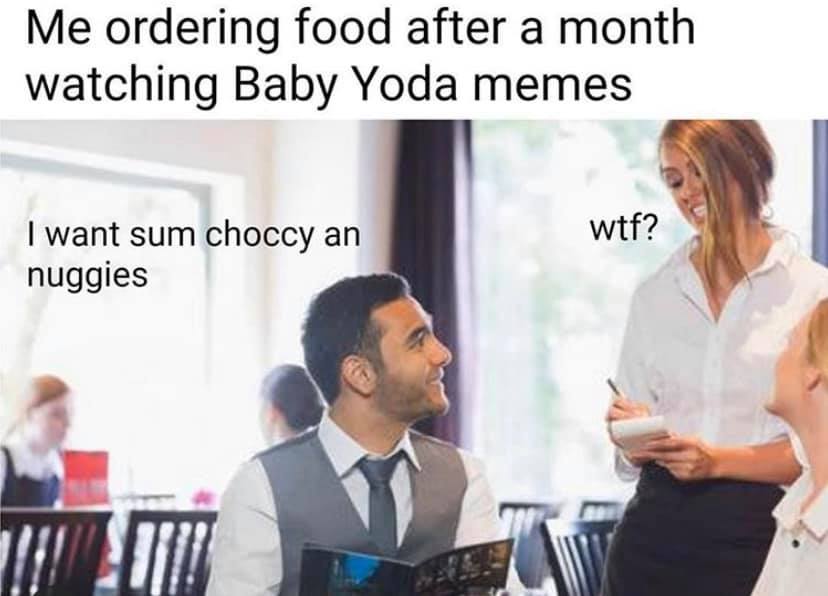 The meme is a photo of a waiter asking a customer if they want to order something. The text overlay reads: "I ordered food and now I'm watching Baby Yoda videos". The joke is that the customer has been distracted by cute videos of the Baby Yoda character from the Star Wars series, and is now unable to focus on their meal.